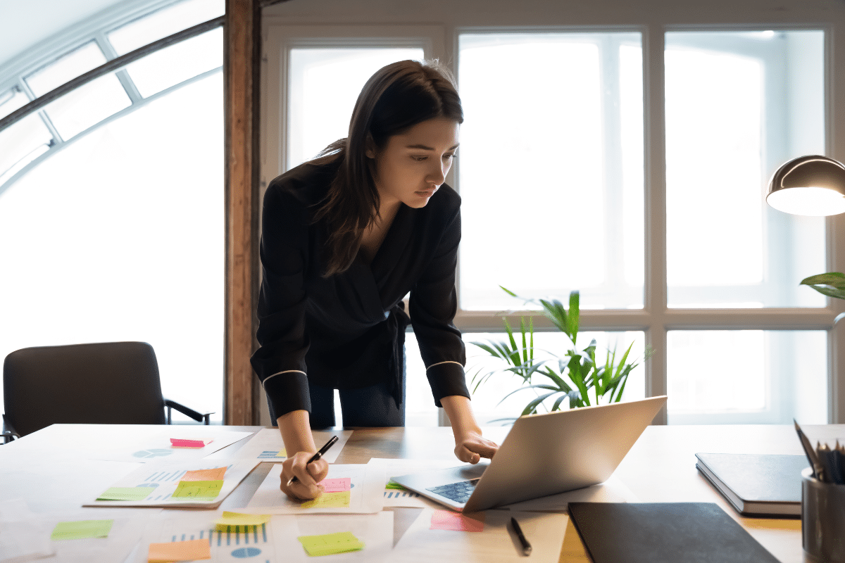 femme d'affaires avec son ordinateur et des documents sur son bureau, travaillant à la création de son entreprise