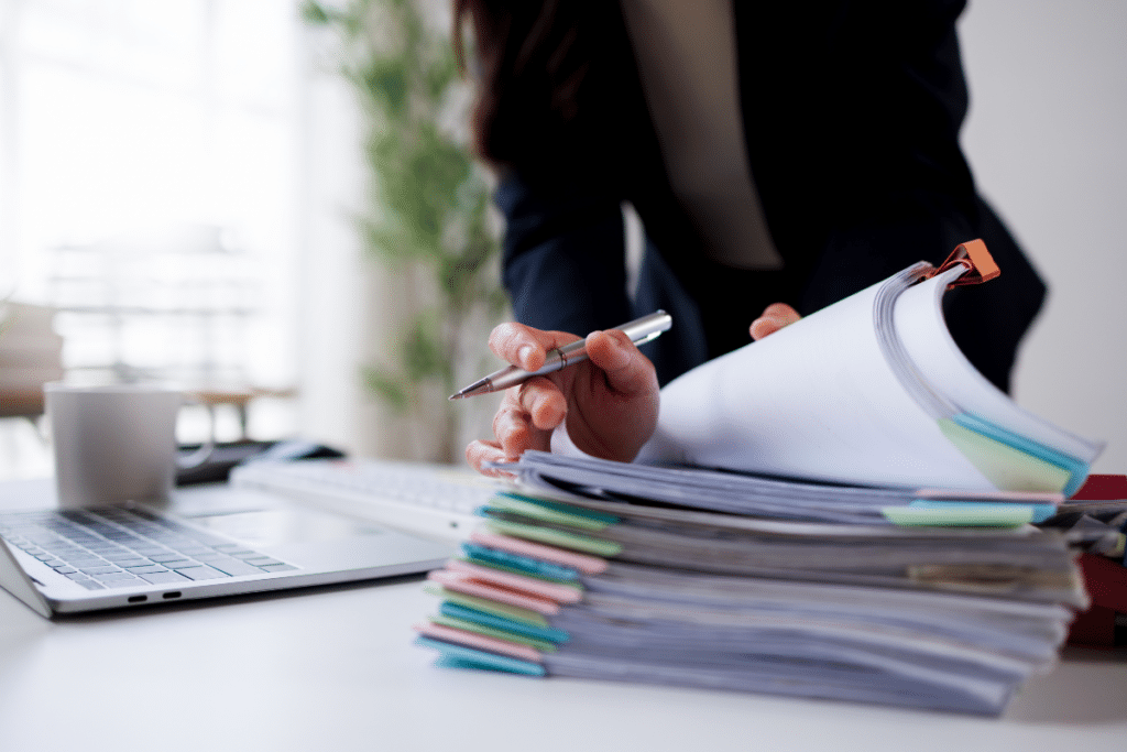 Les mains d'une femme d'affaires au travail, en train de consulter des dossiers