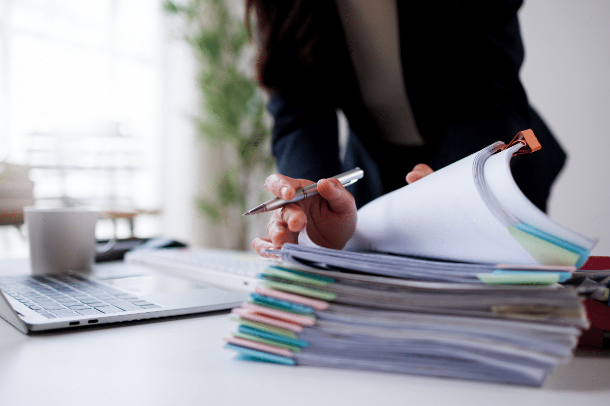 agrément préfectoral de domiciliation Les mains d'une femme d'affaires au travail, en train de consulter des dossiers